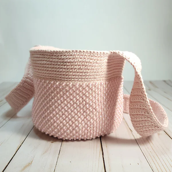 Bolsita crossbody tejida en rosa pastel